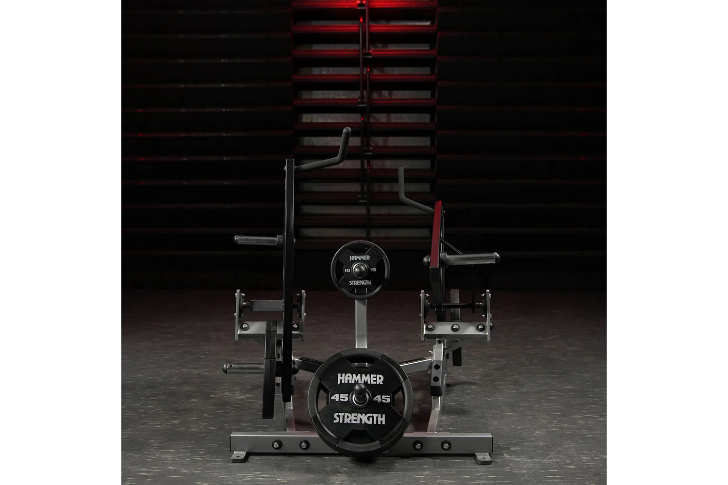 Hammer Strength plate-loaded combo twist machine with black weight plates, curved handles, and red steel frame in gym setting