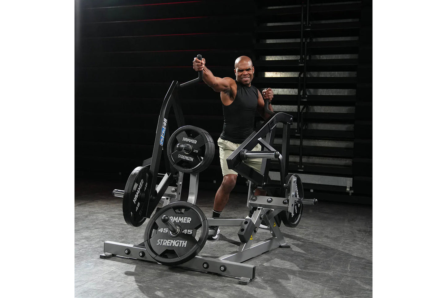 Man using black and silver Hammer Strength plate-loaded combo twist machine with loaded weight plates in gym setting