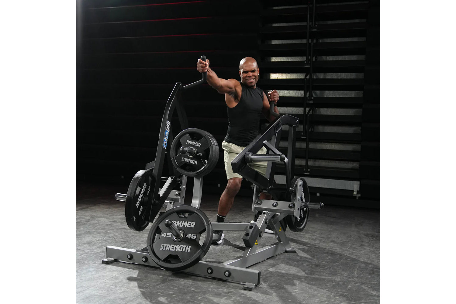 Man using black and silver Hammer Strength plate-loaded combo twist machine with loaded weight plates in gym setting