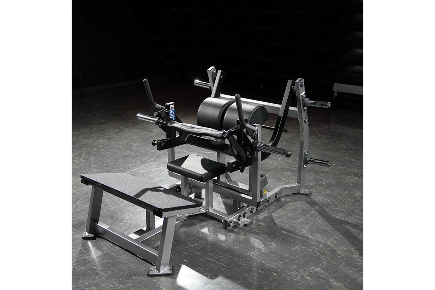 Hammer Strength plate-loaded glute drive machine with silver frame, black padded seat and back support, on gym floor