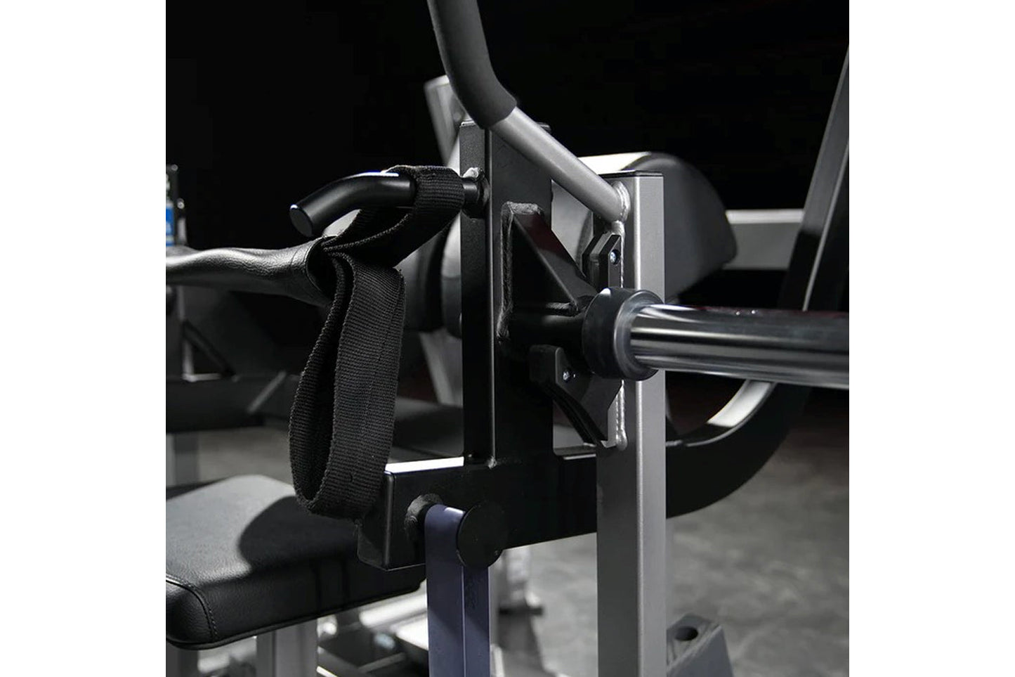 Black nylon strap and metal foot plate attachment on Hammer Strength plate-loaded glute drive machine with gray frame