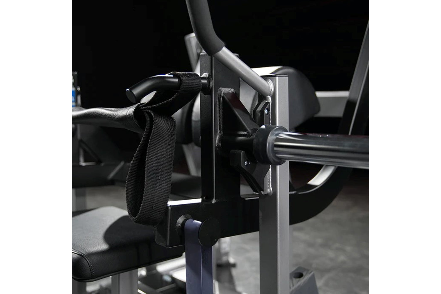 Black nylon strap and metal foot plate attachment on Hammer Strength plate-loaded glute drive machine with gray frame