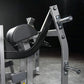 Hammer Strength plate-loaded glute drive machine with black padded seat, chrome handles, and silver steel frame on dark backg