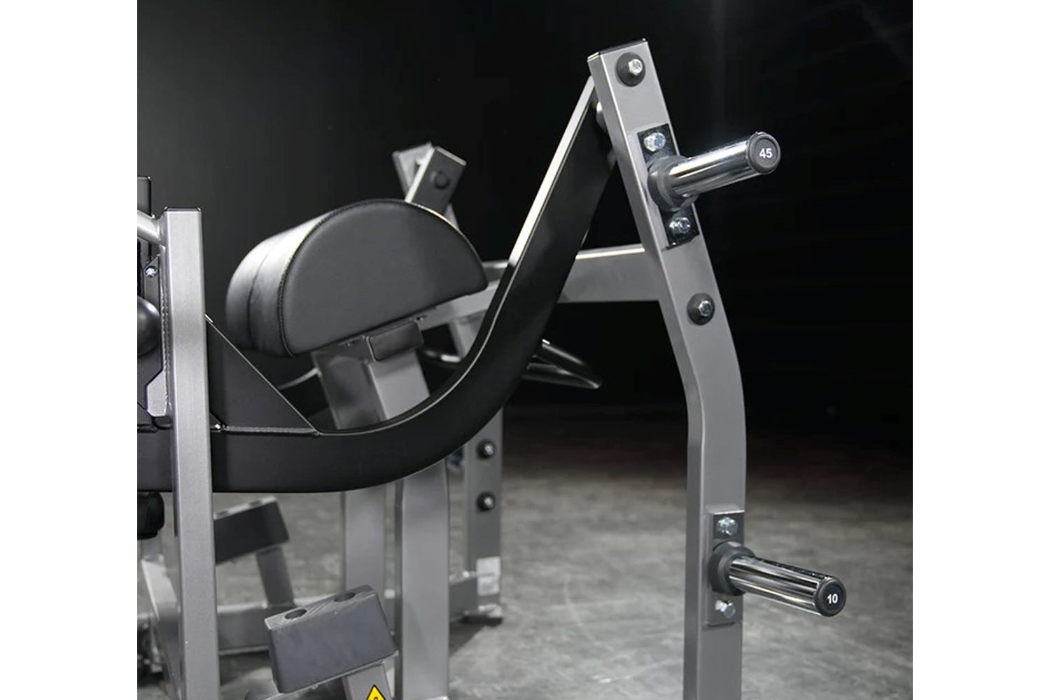 Hammer Strength plate-loaded glute drive machine with black padded seat, chrome handles, and silver steel frame on dark backg