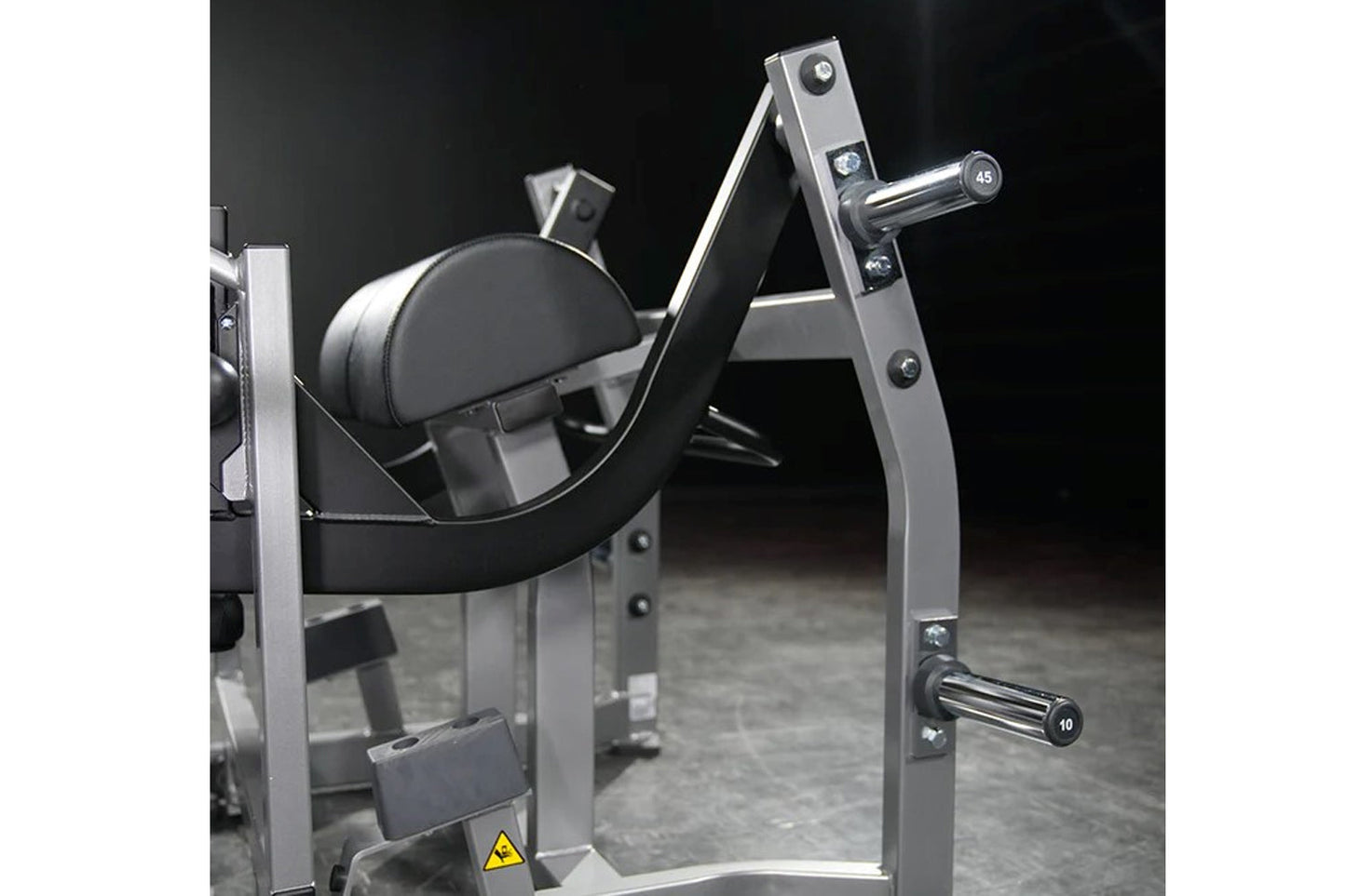 Hammer Strength plate-loaded glute drive machine with silver frame, black padded seat and backrest, chrome handles, on dark b