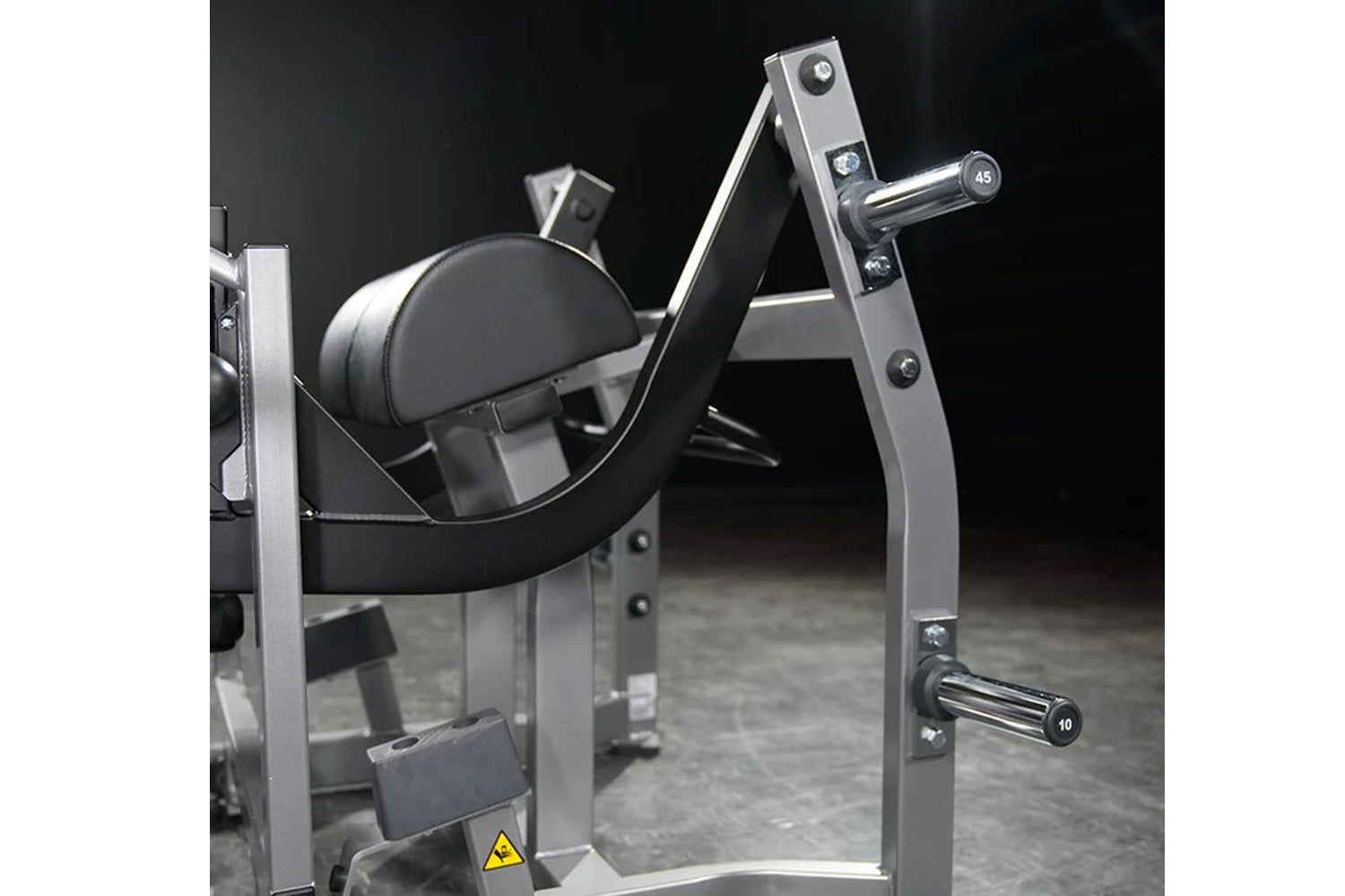 Hammer Strength plate-loaded glute drive machine with silver frame, black padded seat and backrest, chrome handles, on dark b