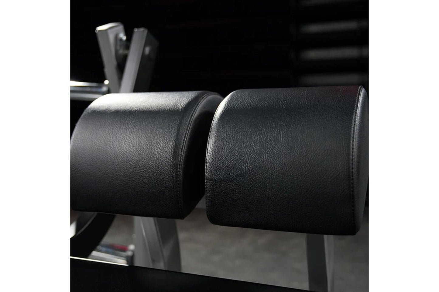 Pair of black leather cylindrical leg press pads on Hammer Strength fitness equipment