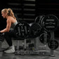 Blonde woman in gray sports bra and black pants performing glute drive exercise on Hammer Strength black plate-loaded machine