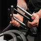 Person holding two plate-loaded grippers with black handles and metal cylinders against black background
