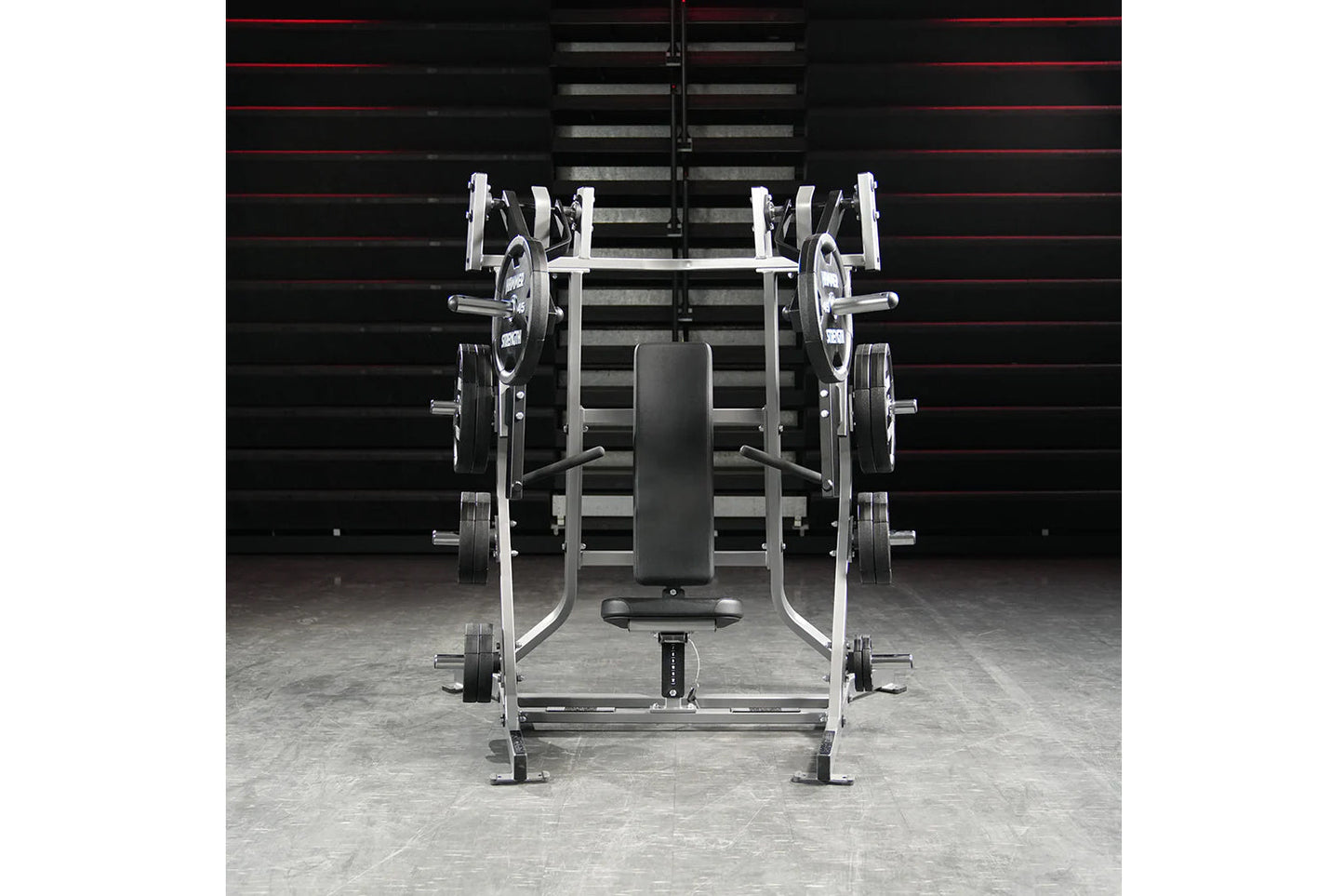 Hammer Strength plate-loaded iso-lateral bench press with white frame, black padded seat, and loaded weight plates in gym set