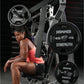 Woman in coral tank top and black shorts seated on Hammer Strength plate-loaded bench press machine with black weight plates