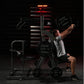Man performing chest press on Hammer Strength black plate-loaded machine in gym with red lighting overhead