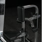 Hammer Strength plate-loaded chest/back machine with black padded seat and backrest, gray metal frame, against black backgrou
