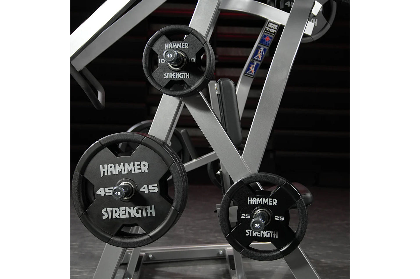 Hammer Strength weight plates in 10, 25, and 45 pounds mounted on silver and black plate-loaded iso-lateral rowing machine