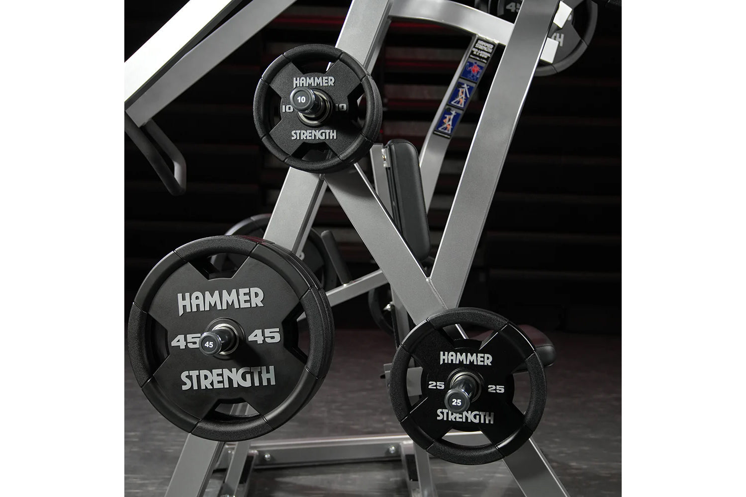 Hammer Strength weight plates in 10, 25, and 45 pounds mounted on silver and black plate-loaded iso-lateral rowing machine