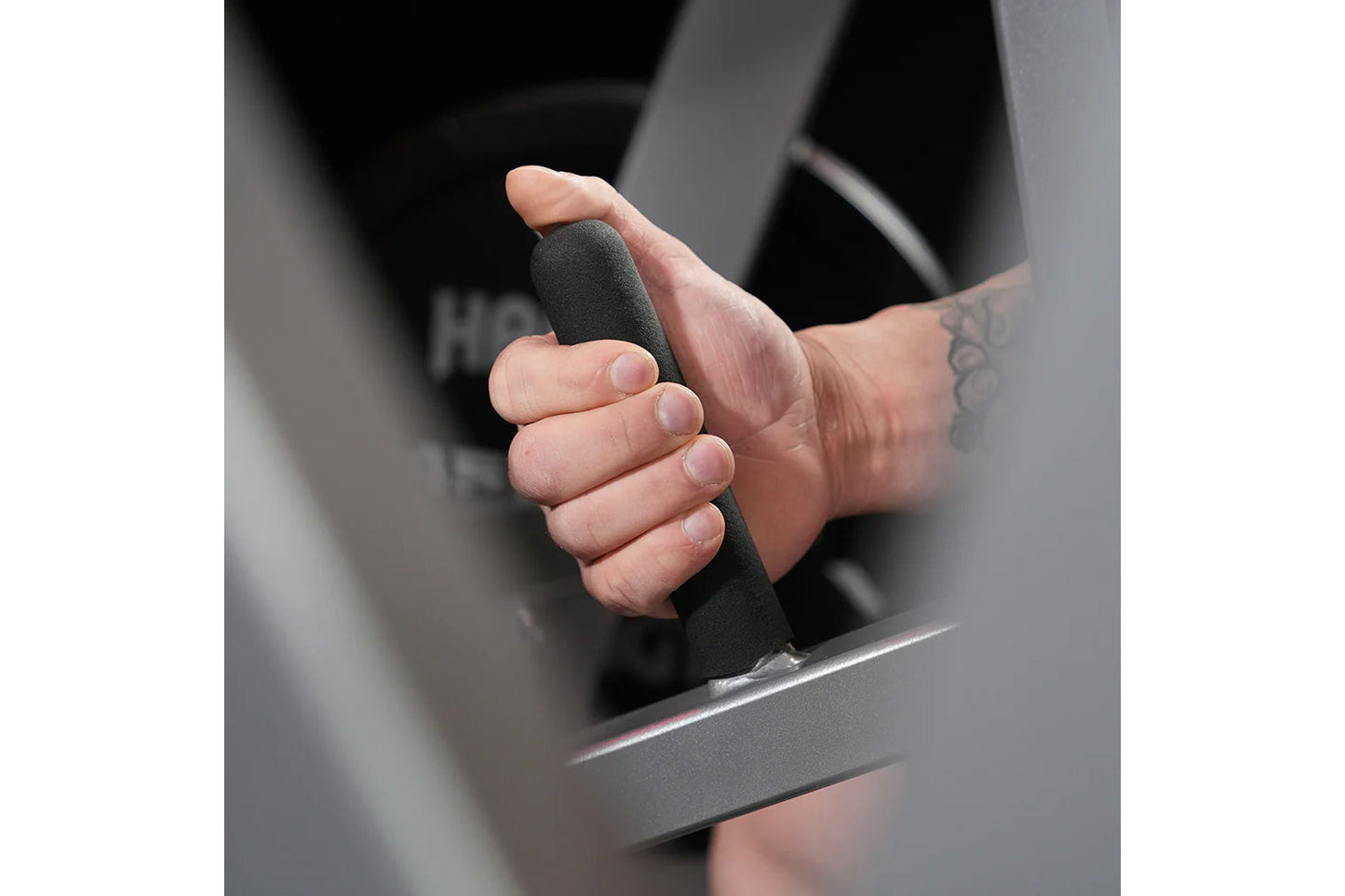 Child's hand gripping black foam handle of exercise equipment in close-up detail