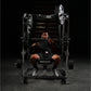 Man wearing black shirt and shorts using Hammer Strength plate-loaded decline chest press machine with loaded weight plates i