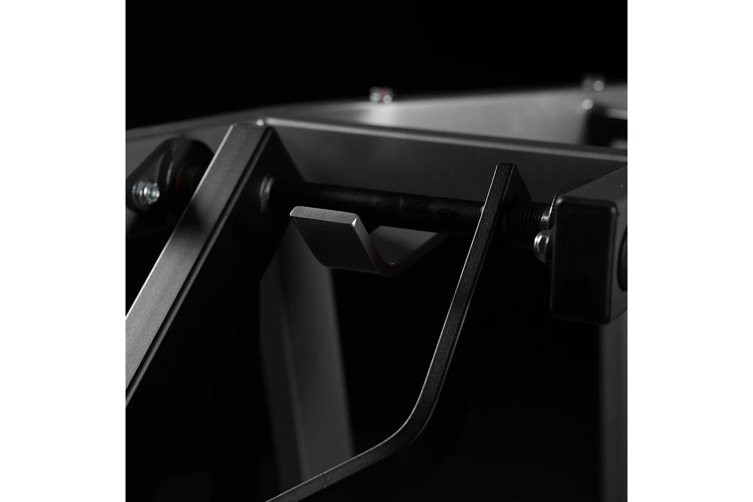 Black plate-loaded chest press machine with dual handles and metal frame detail, close-up side view on white background