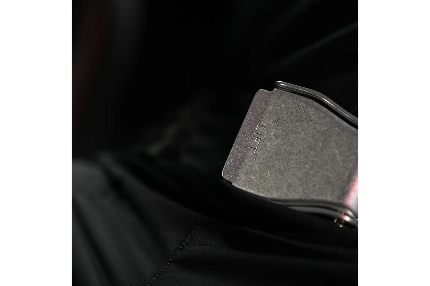 Black metal weight plate with "LTM" branding detail on dark background