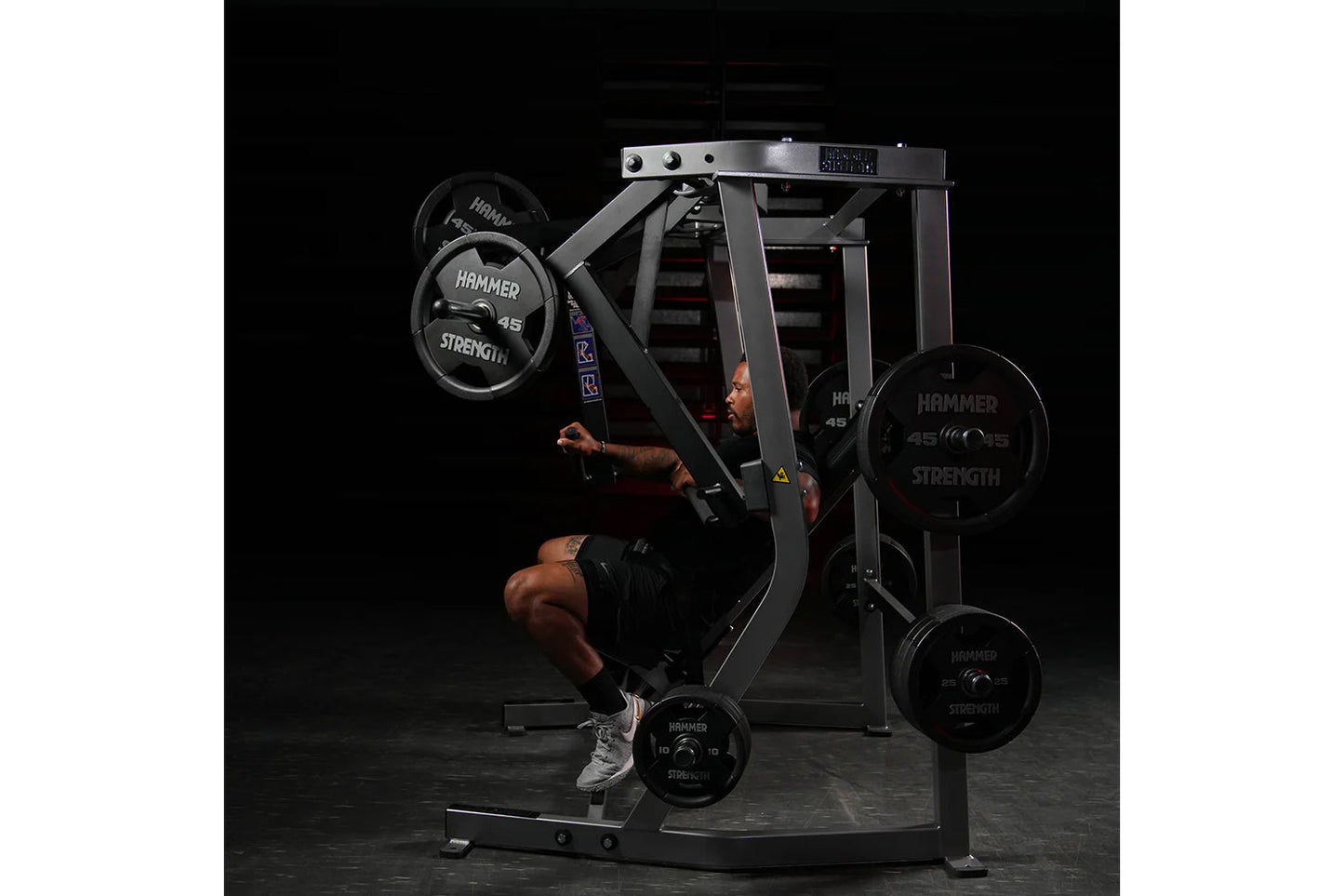 Hammer Strength plate-loaded iso-lateral decline chest press machine with athlete demonstrating exercise, black metal frame w