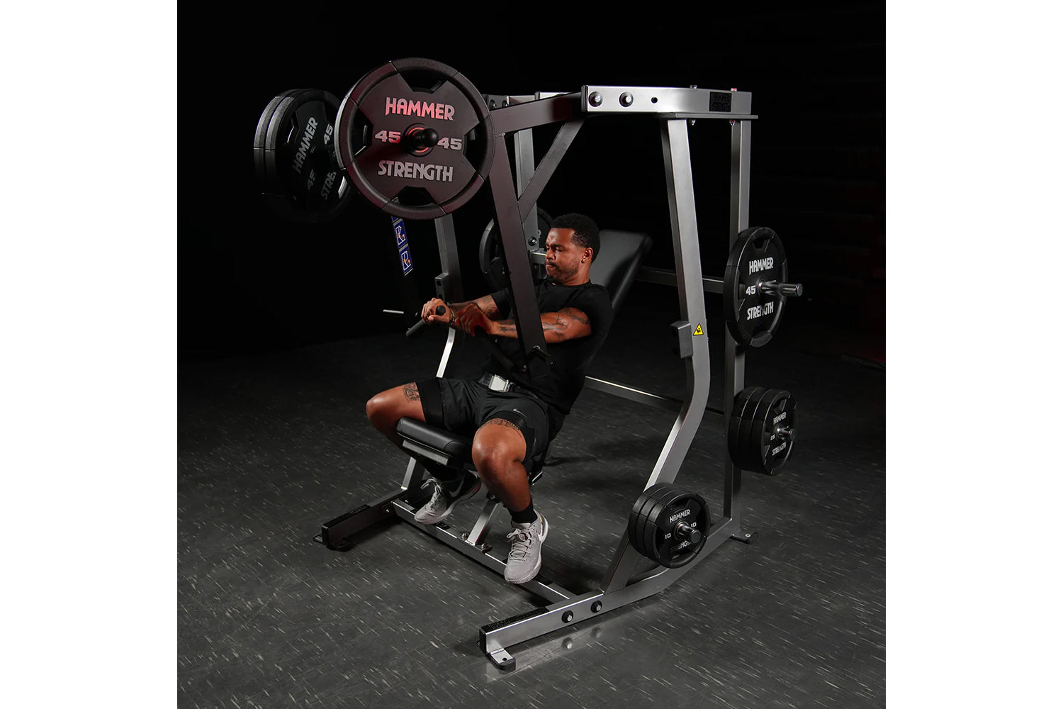 Hammer Strength plate-loaded iso-lateral decline chest press machine with 45-pound plates, man using machine on black gym flo