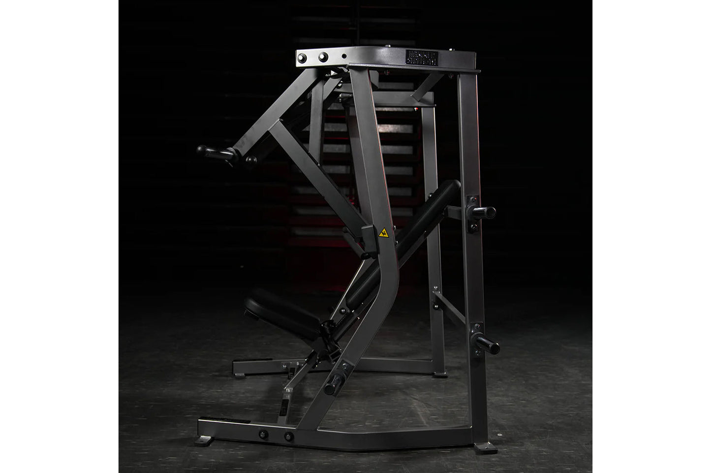 Black plate-loaded iso-lateral decline chest press machine with gray frame and padded seat, shown on dark background
