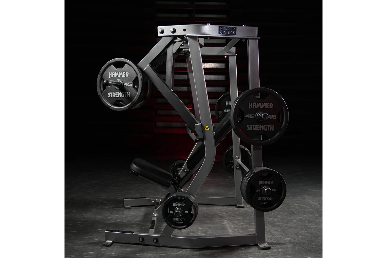 Hammer Strength plate-loaded iso-lateral decline chest press machine with black weight plates on dark background