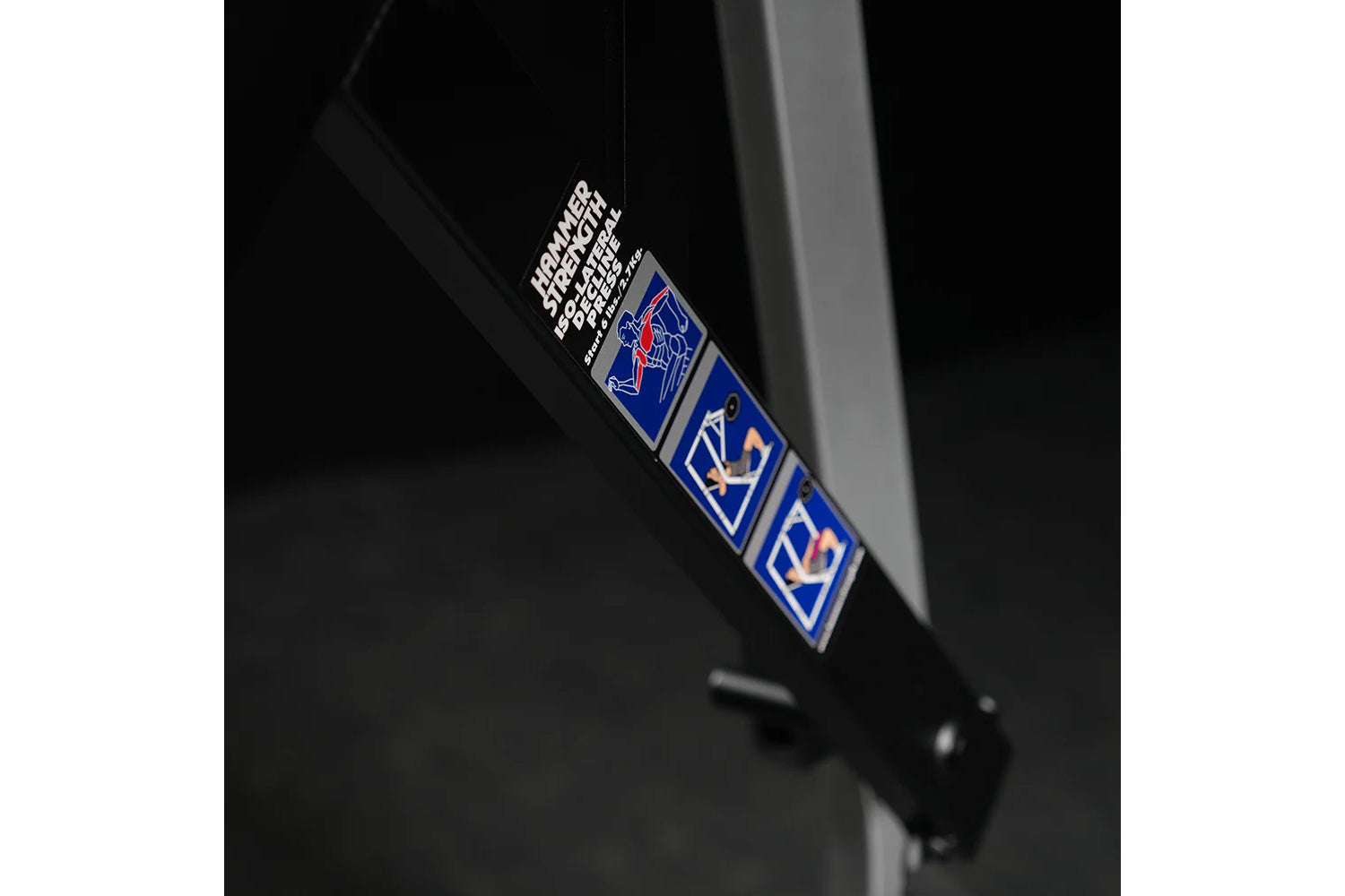 Black nylon strap with white and blue logo patches hanging against dark background