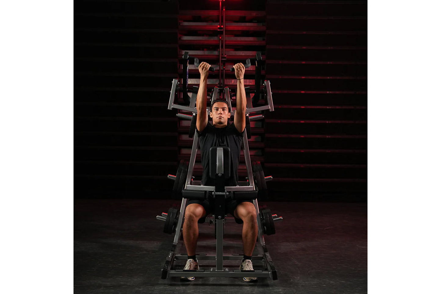 Man using black and red Hammer Strength plate-loaded lat pulldown machine, performing front lat pulldown exercise