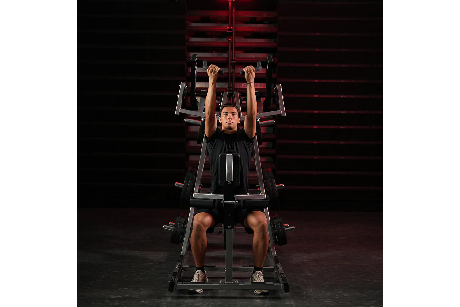 Man using black and red Hammer Strength plate-loaded lat pulldown machine, performing front lat pulldown exercise