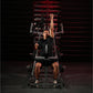 Man in black shirt and shorts performing lat pulldown exercise on Hammer Strength plate-loaded machine with red-lit backgroun