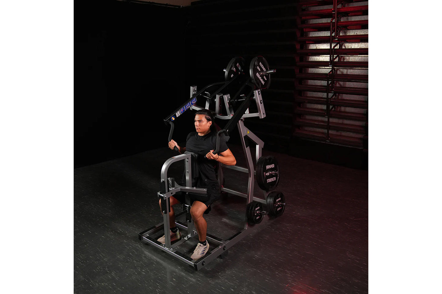 Man using black and silver Hammer Strength plate-loaded iso-lateral front lat pulldown machine in gym setting