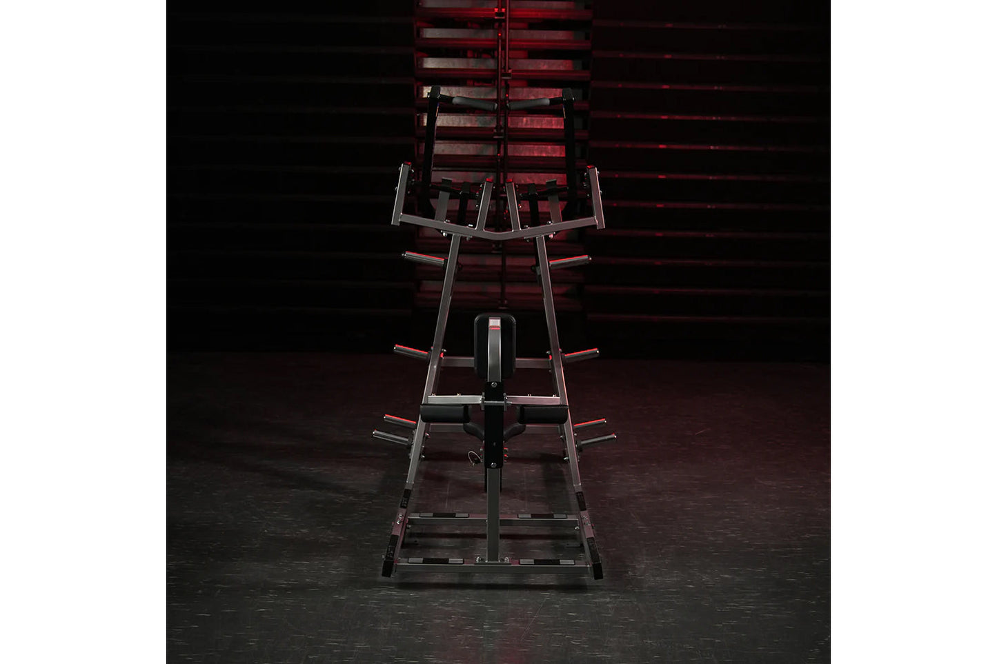 Hammer Strength plate-loaded iso-lateral front lat pulldown machine with black and red frame, viewed from front on dark backg
