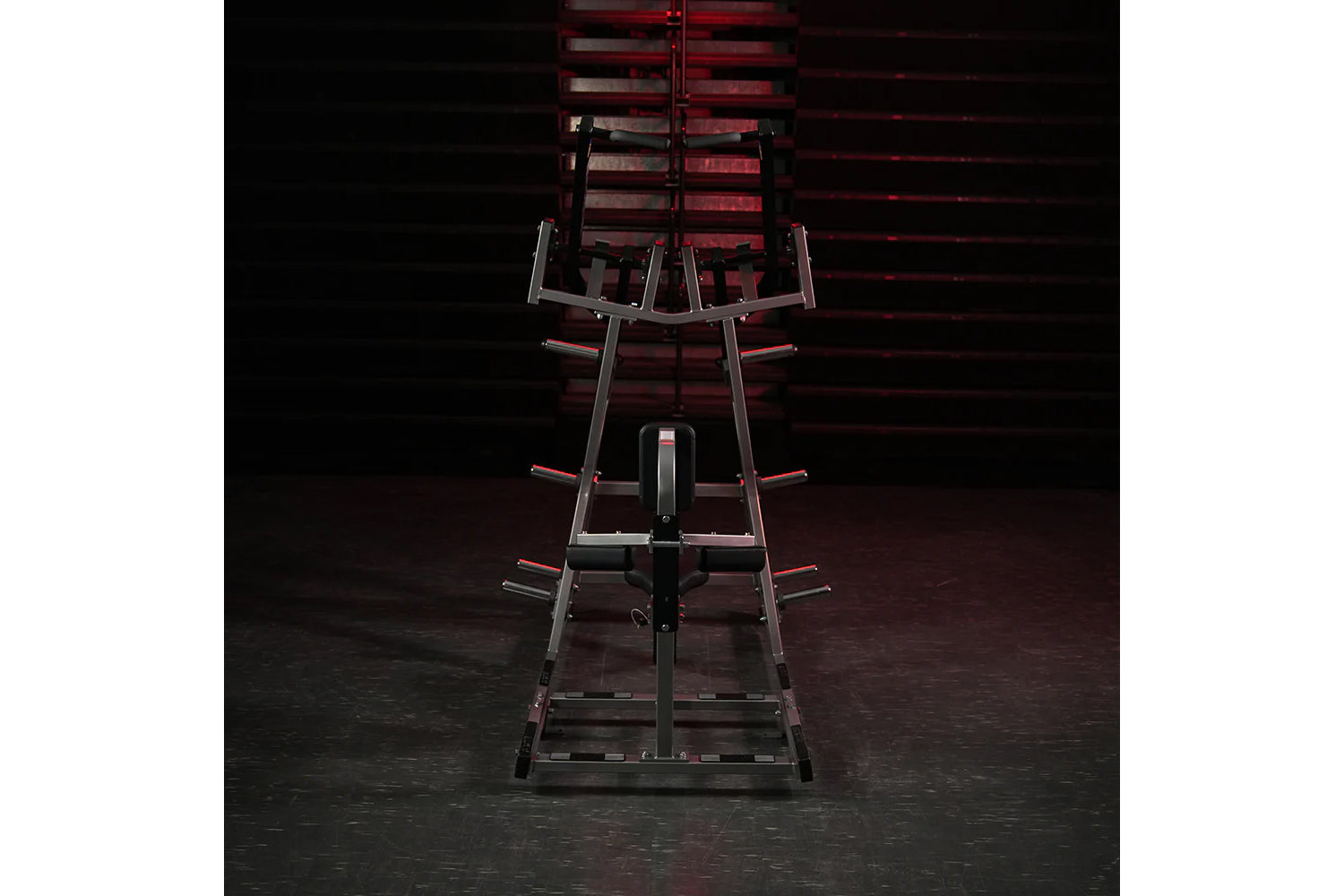Hammer Strength plate-loaded iso-lateral front lat pulldown machine with black and red frame, viewed from front on dark backg