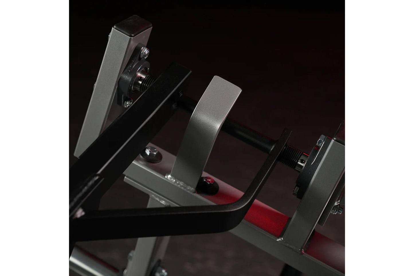 Hammer Strength plate-loaded iso-lateral horizontal bench press with gray metal frame and red padded seat on black background