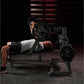 Male athlete performing chest press exercise on black Hammer Strength plate-loaded bench with weights loaded, in gym setting
