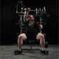 Man wearing black Broken Barrel t-shirt performing incline press exercise on plate-loaded weight machine in gym setting