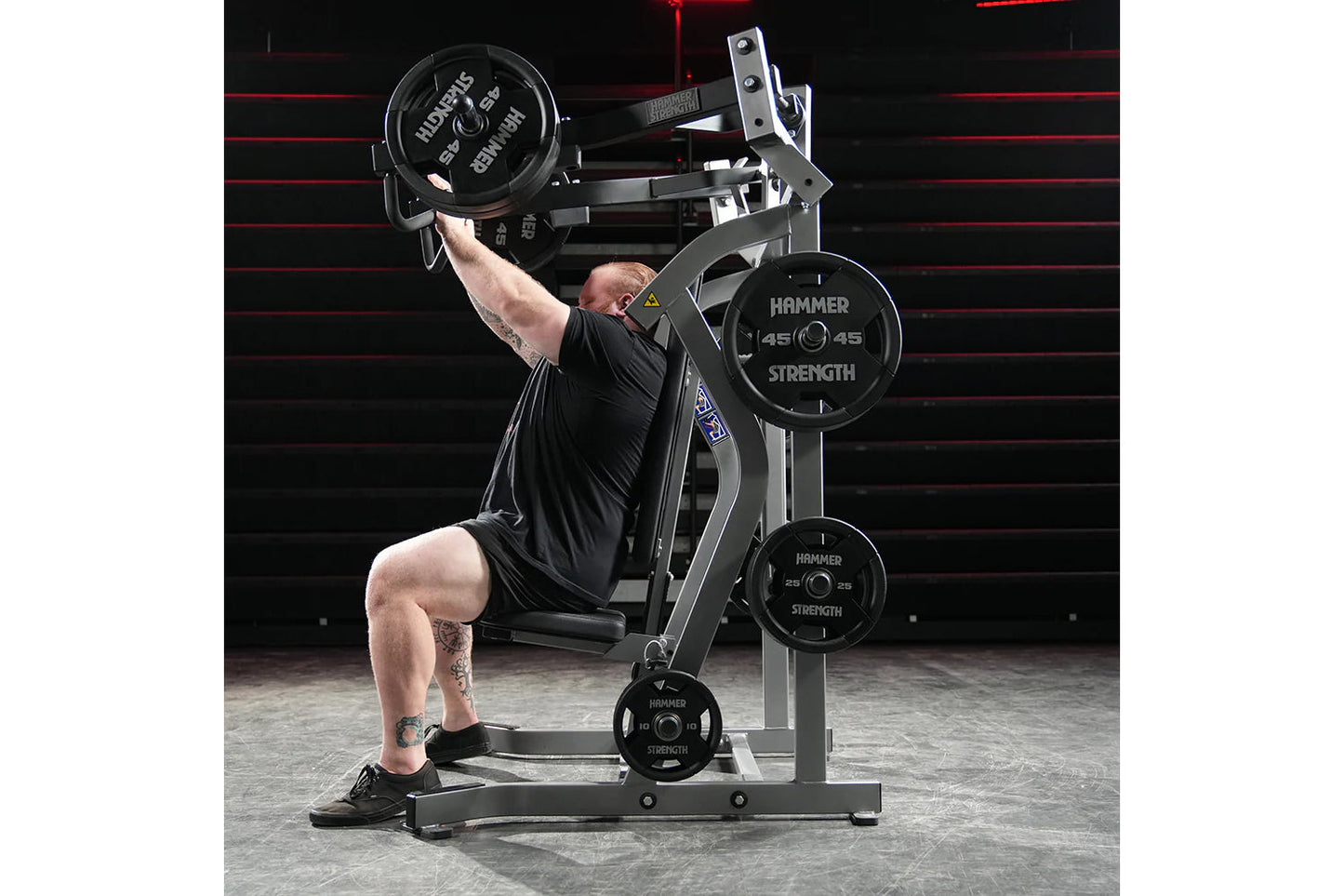 Hammer Strength plate-loaded iso-lateral incline press machine with weighted plates, demonstrated by user in black shirt perf