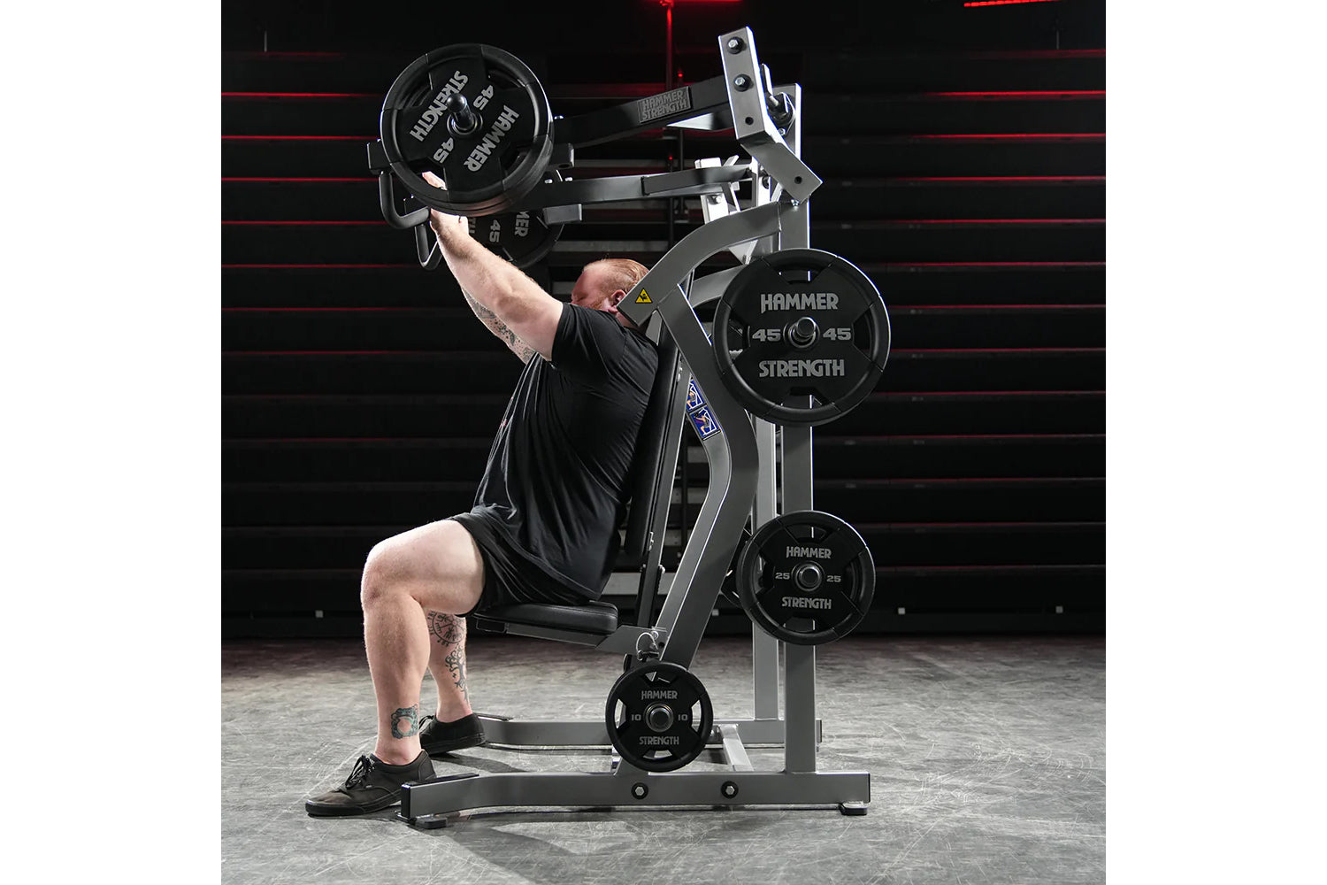 Hammer Strength plate-loaded iso-lateral incline press machine with weighted plates, demonstrated by user in black shirt perf