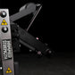 Hammer Strength plate-loaded leg curl machine with gray and black frame, dual control handles, and yellow caution decals on b