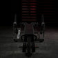 Black plate-loaded iso-lateral leg curl machine with padded seat and dual leg extension arms in gym setting