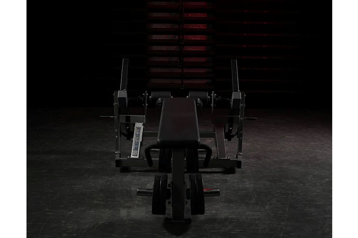 Black plate-loaded iso-lateral leg curl machine with padded seat and dual leg extension arms in gym setting