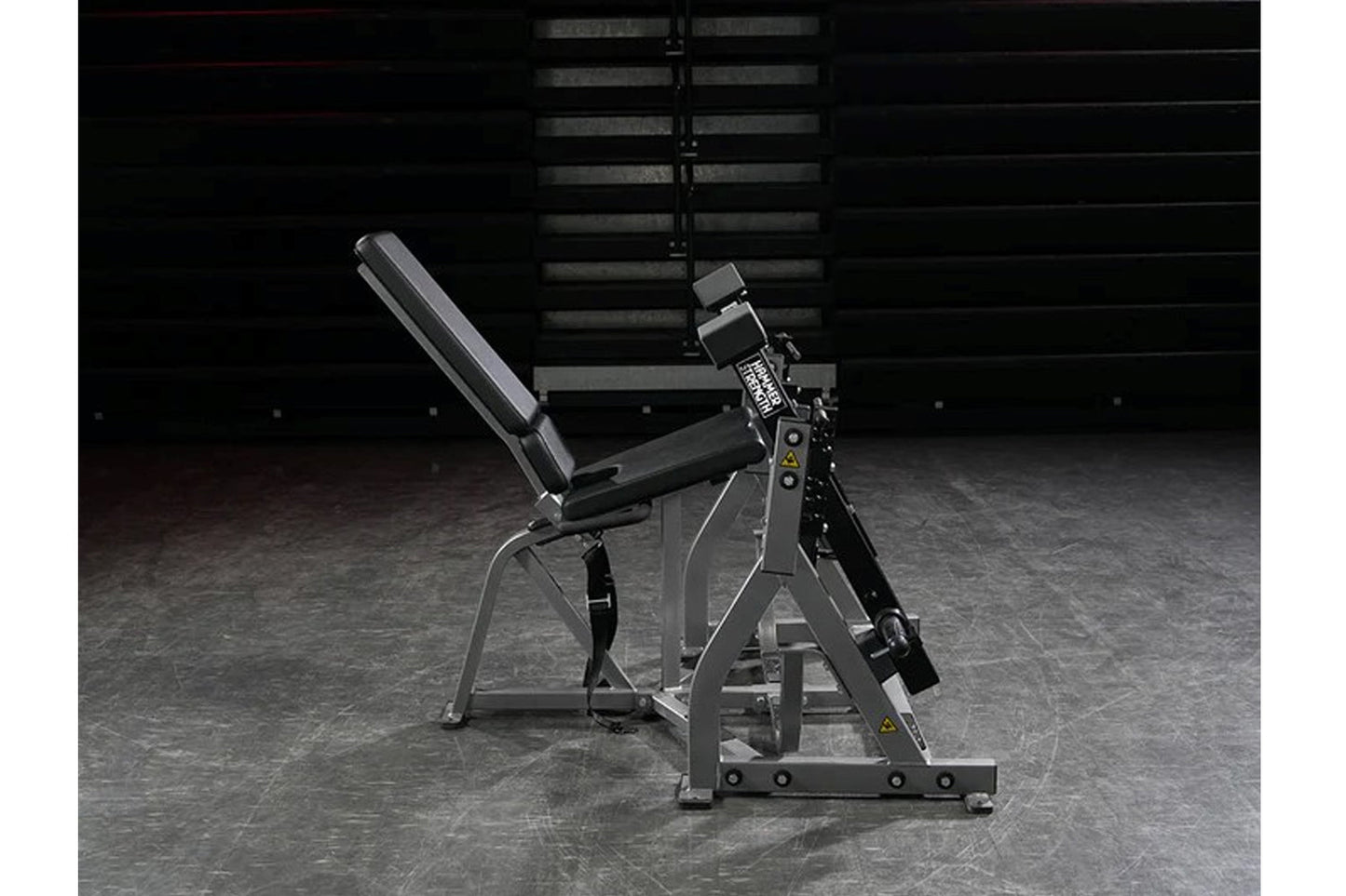 Hammer Strength plate-loaded iso-lateral leg extension machine with gray frame, black padded seat, and digital display on gym