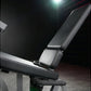 Black leather and metal leg extension machine with padded seat and armrests, displayed in gym setting under studio lighting