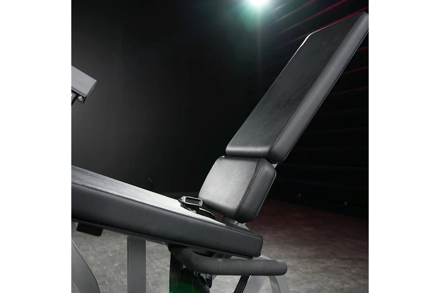 Black leather and metal leg extension machine with padded seat and armrests, displayed in gym setting under studio lighting