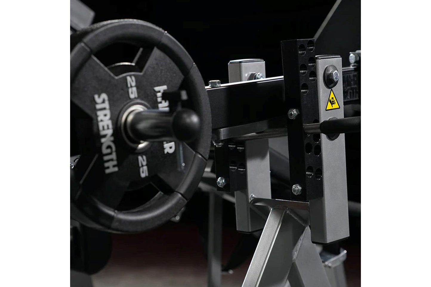 Hammer Strength plate-loaded iso-lateral leg extension machine with black rubber grips and metal frame on black background