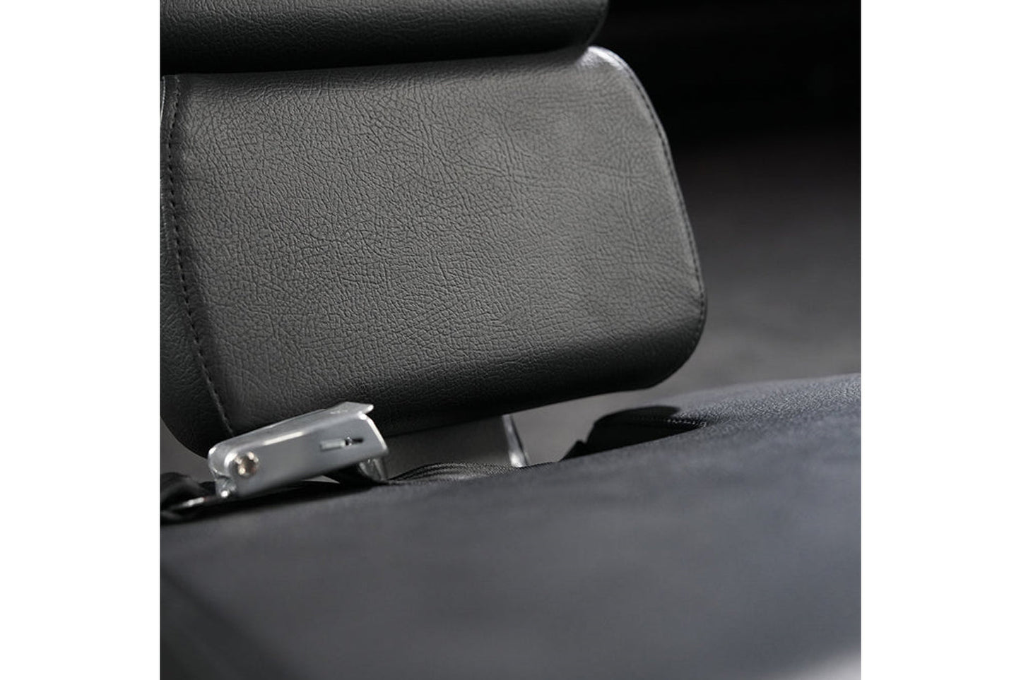 Black padded leg extension machine seat with metal adjustment lever and textured leather surface