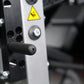 White and black Hammer Strength leg extension machine with yellow caution triangle and control buttons, close-up detail view