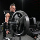 Man using black plate-loaded leg extension machine with loaded weight plates in gym setting