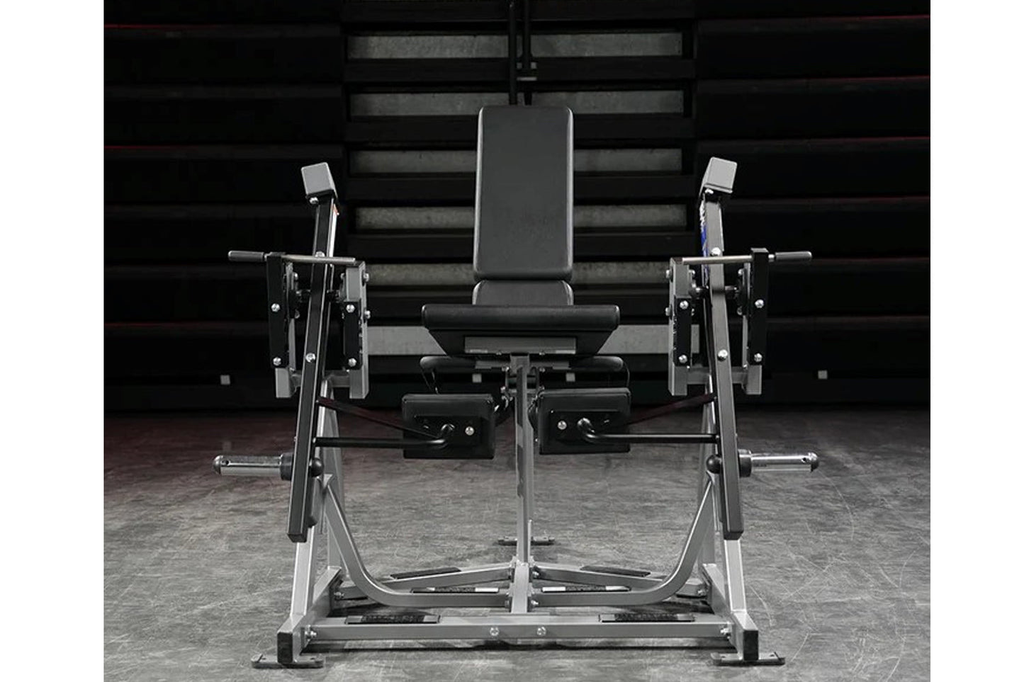 Hammer Strength plate-loaded iso-lateral leg extension machine with black padded seat and silver frame, front view on gym flo